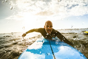 surfer paddling out to ocean