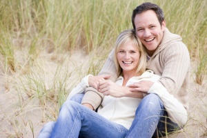 couple sitting on beach smiling with their Medicare Supplement Plans